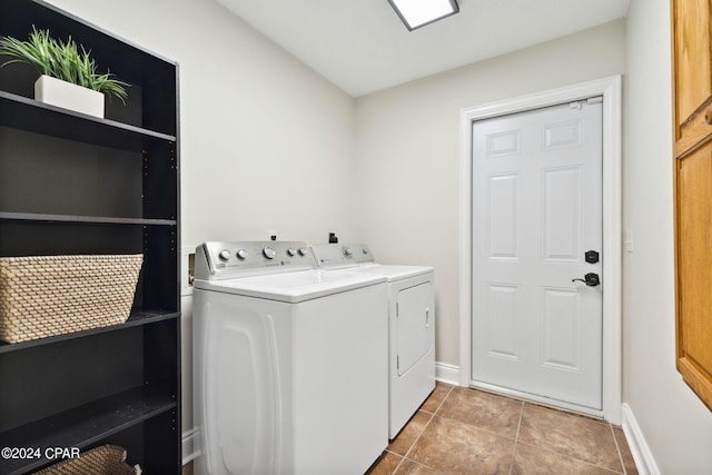 clothes washing area featuring light tile patterned floors and washer and clothes dryer