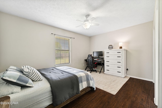 bedroom with hardwood / wood-style flooring, ceiling fan, and a textured ceiling