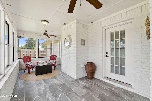 sunroom / solarium featuring ceiling fan