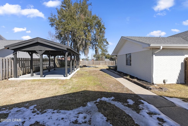 yard covered in snow with a gazebo and a patio area