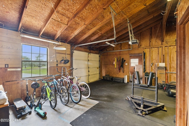 garage with a garage door opener and wooden walls