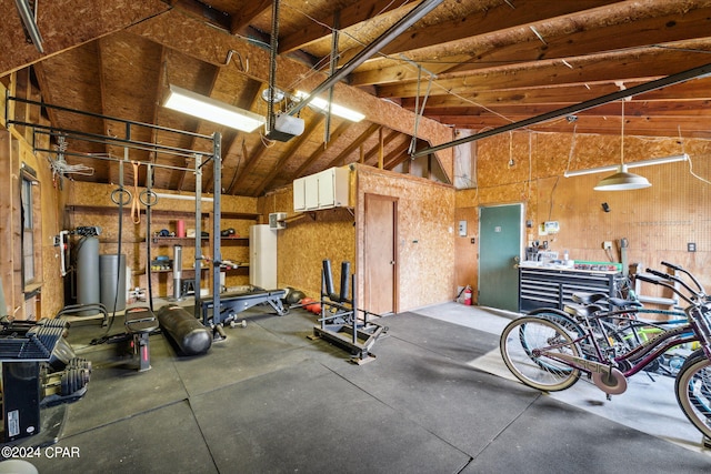 garage with a garage door opener, a workshop area, and wood walls