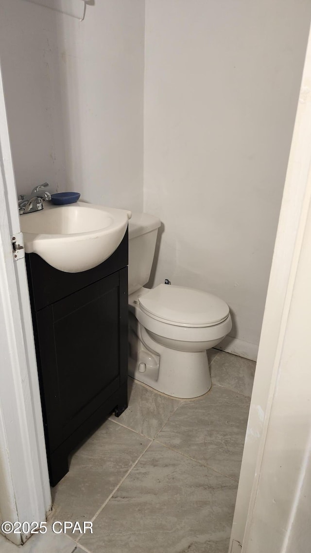 bathroom featuring tile patterned floors, vanity, and toilet