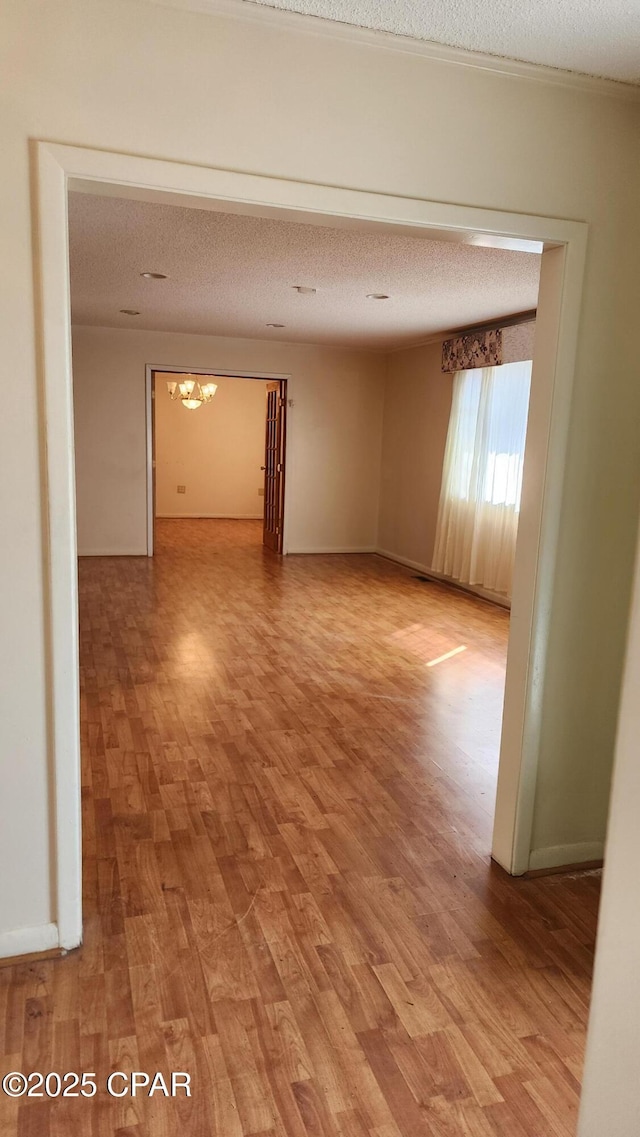 unfurnished room with hardwood / wood-style floors and a textured ceiling