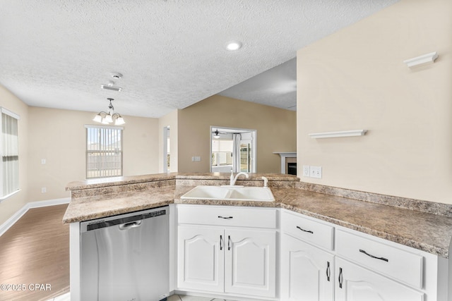 kitchen featuring white cabinetry, stainless steel dishwasher, kitchen peninsula, and sink