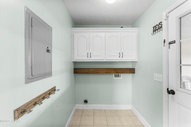 washroom with cabinets, a textured ceiling, light tile patterned floors, electric panel, and hookup for a washing machine