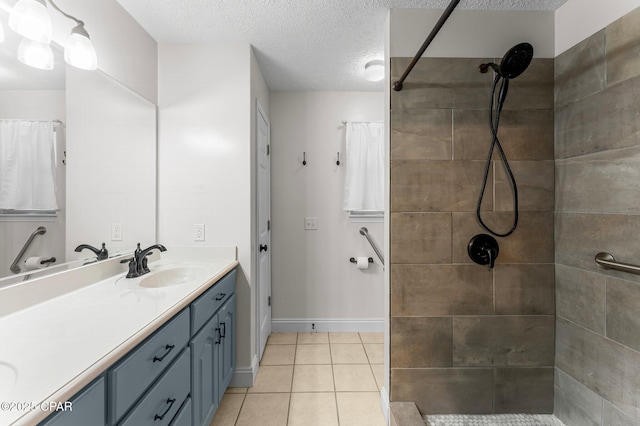 bathroom with vanity, tile patterned flooring, a textured ceiling, and a tile shower