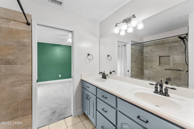 bathroom featuring vanity, tile patterned floors, and a textured ceiling