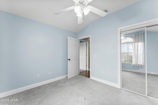 unfurnished bedroom featuring ceiling fan, lofted ceiling, light carpet, and a closet