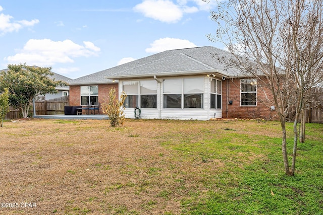 back of property with a yard and a patio