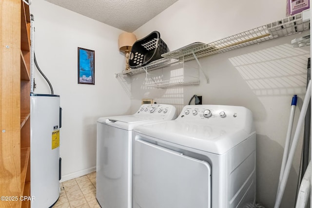 laundry room featuring electric water heater, washing machine and clothes dryer, and a textured ceiling