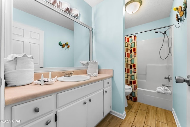 full bathroom featuring vanity, shower / tub combo with curtain, a textured ceiling, and toilet