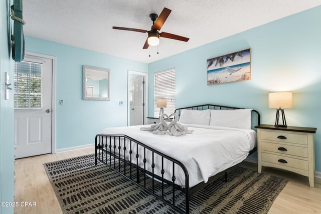 bedroom featuring a textured ceiling, light hardwood / wood-style floors, and ceiling fan