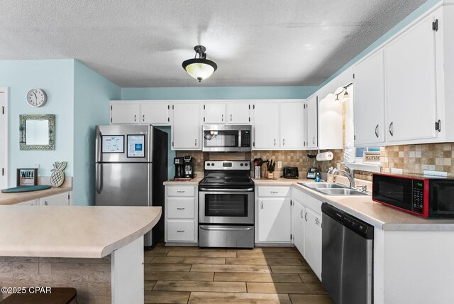 17214 Front Beach Rd Unit T28, Panama City Beach, FL 32413 - kitchen featuring appliances with stainless steel finishes, a sink, light countertops, wood tiled floors, and decorative backsplash