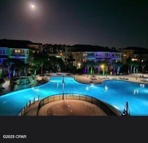 view of pool at twilight