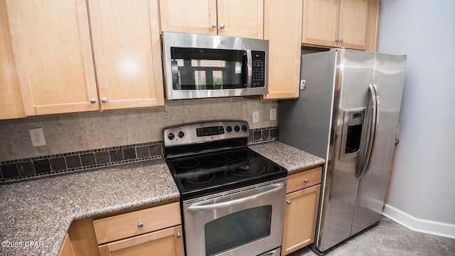 kitchen with stainless steel appliances, light brown cabinets, and backsplash