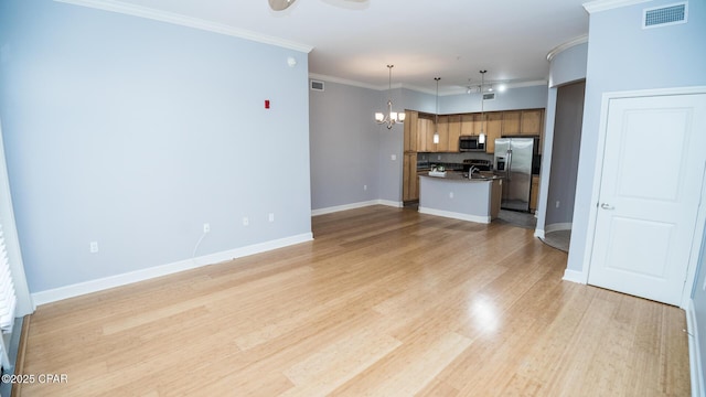 unfurnished living room featuring crown molding, an inviting chandelier, and light hardwood / wood-style flooring