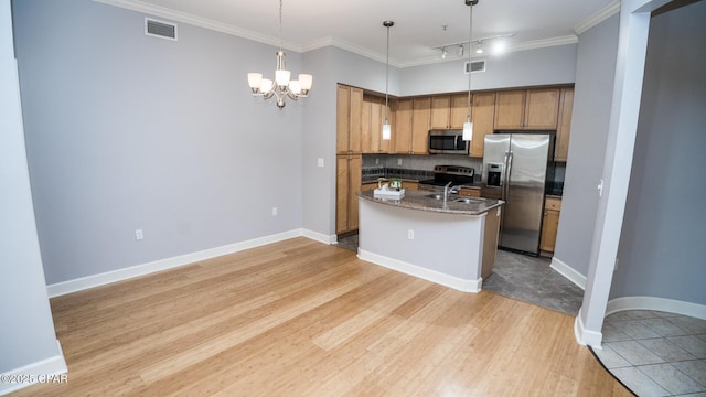 kitchen featuring pendant lighting, sink, stainless steel appliances, crown molding, and a center island with sink