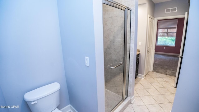 bathroom featuring toilet, vanity, tile patterned floors, and a shower with shower door