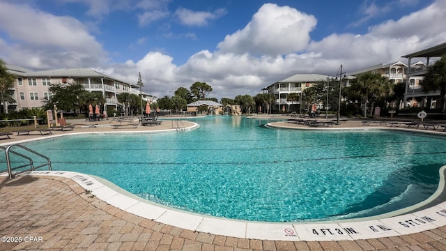 view of swimming pool with a patio area and a water slide