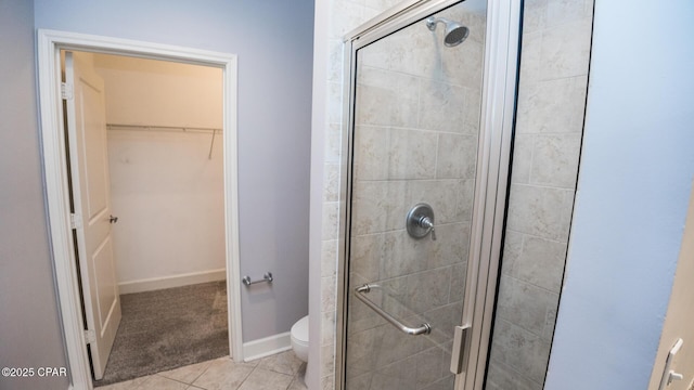 bathroom with a shower with shower door, tile patterned floors, and toilet