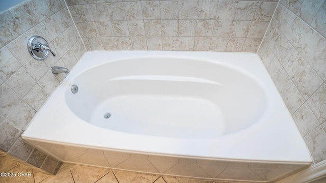 bathroom with tile patterned flooring and a tub