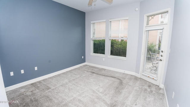 carpeted spare room with a wealth of natural light and ceiling fan