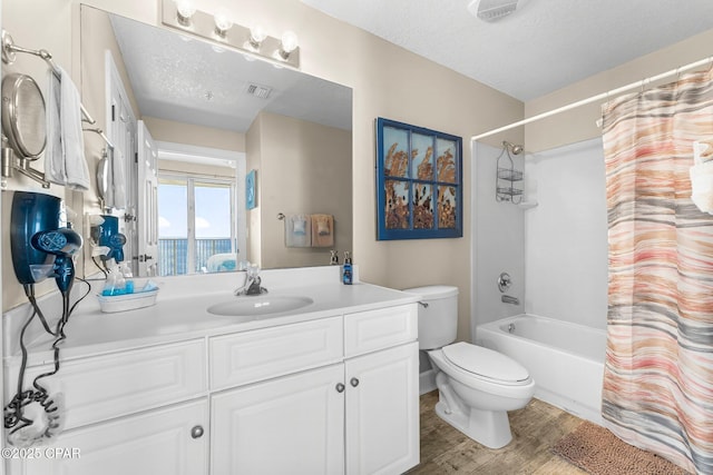 full bathroom with shower / bathtub combination with curtain, hardwood / wood-style flooring, vanity, a textured ceiling, and toilet