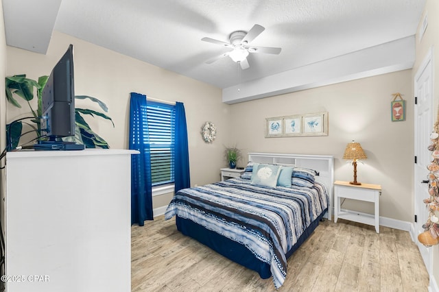 bedroom with a textured ceiling, ceiling fan, and light hardwood / wood-style flooring