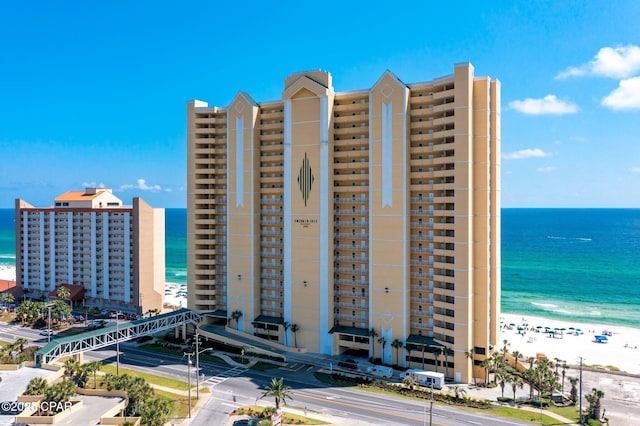 view of building exterior with a water view and a view of the beach