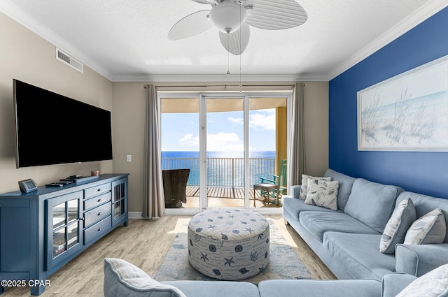 living room featuring crown molding, ceiling fan, a textured ceiling, and light wood-type flooring