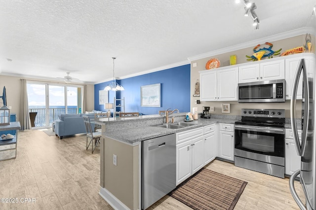 kitchen featuring sink, kitchen peninsula, white cabinets, and appliances with stainless steel finishes