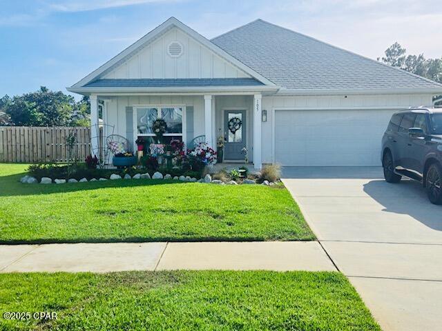 view of front of property featuring concrete driveway, roof with shingles, fence, a front lawn, and a garage