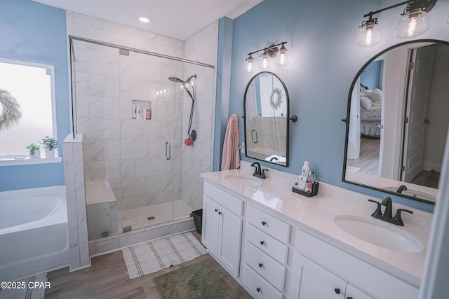 bathroom with hardwood / wood-style flooring, plenty of natural light, plus walk in shower, and vanity