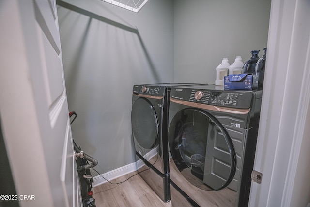 laundry room with baseboards, independent washer and dryer, laundry area, and wood finished floors