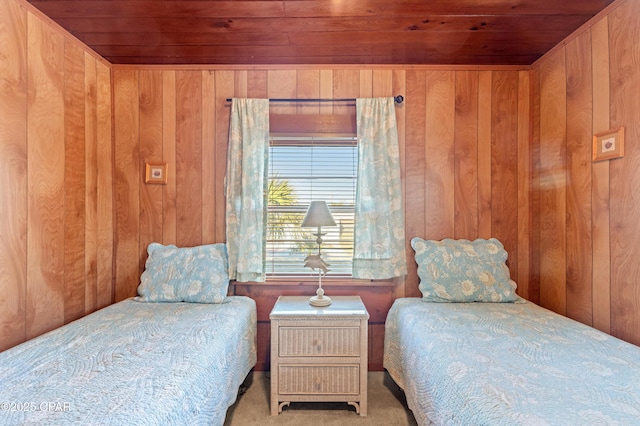 carpeted bedroom with wood ceiling and wooden walls