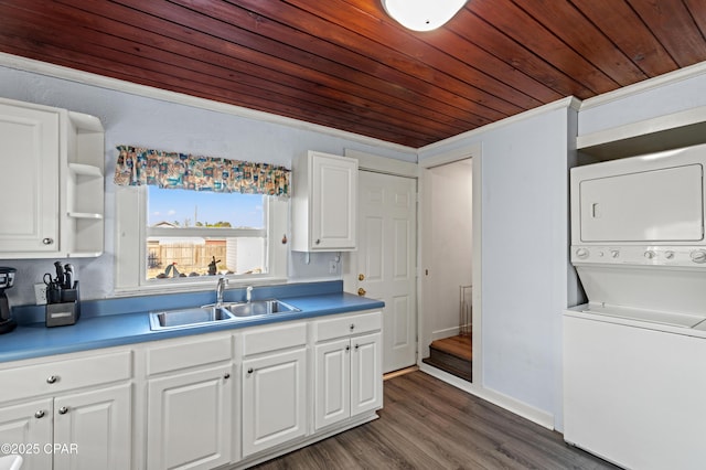 kitchen featuring wooden ceiling, stacked washing maching and dryer, white cabinetry, and a sink