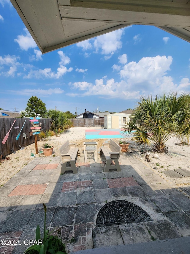 view of patio / terrace with an outdoor structure and a fenced backyard