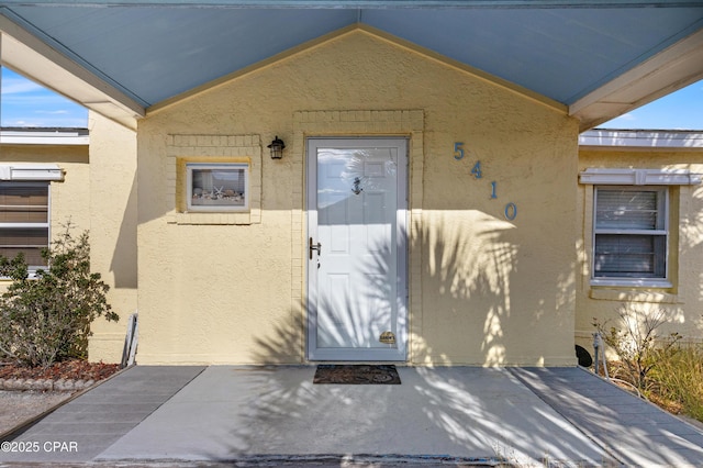 property entrance with stucco siding