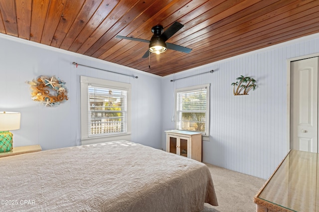 carpeted bedroom featuring a ceiling fan, wooden ceiling, and crown molding