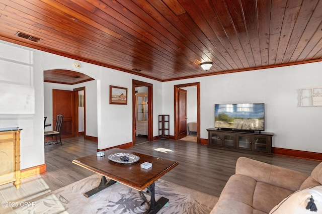 living area with arched walkways, wood finished floors, visible vents, baseboards, and ornamental molding