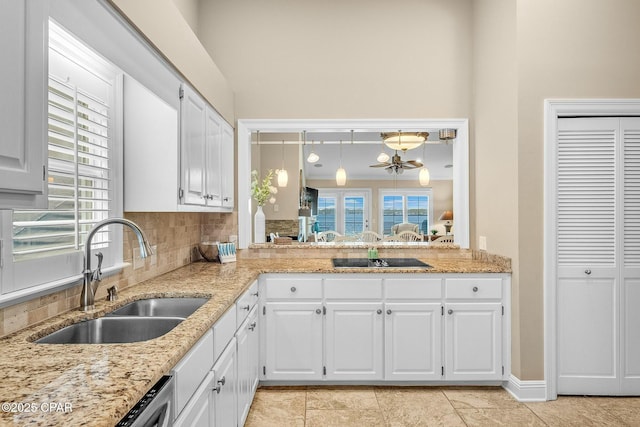 kitchen featuring pendant lighting, sink, white cabinets, backsplash, and plenty of natural light