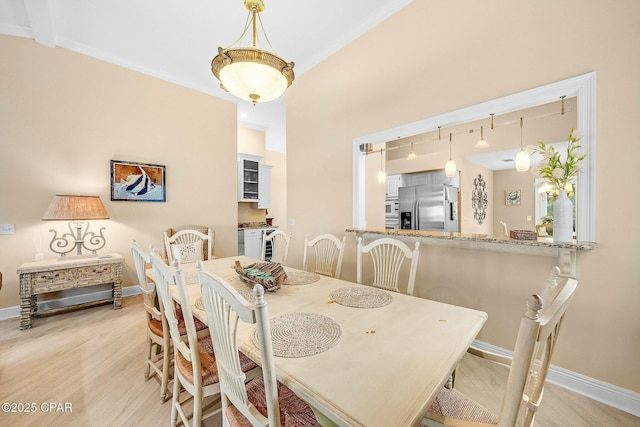 dining area with crown molding and light hardwood / wood-style flooring