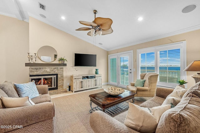 living room with vaulted ceiling, a stone fireplace, ceiling fan, and crown molding