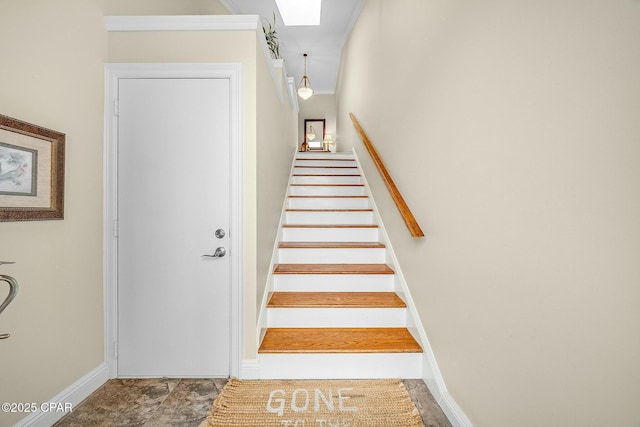 staircase featuring crown molding and a skylight