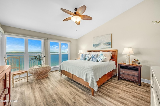 bedroom with a water view, ceiling fan, vaulted ceiling, and light hardwood / wood-style flooring