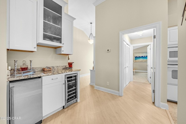 kitchen with pendant lighting, white cabinetry, white appliances, and beverage cooler