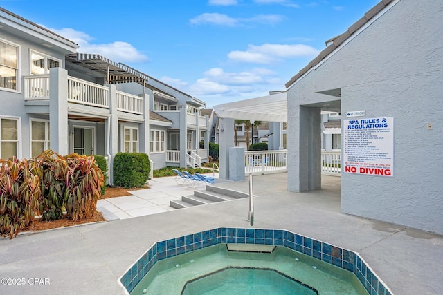 view of swimming pool with a hot tub and a pergola