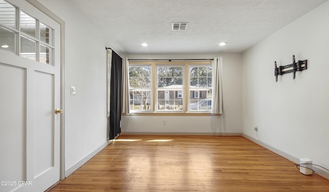 interior space featuring light hardwood / wood-style flooring and a textured ceiling