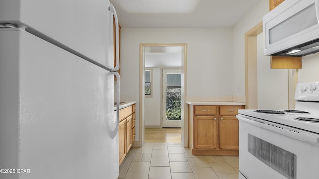 kitchen featuring light tile patterned floors and white appliances